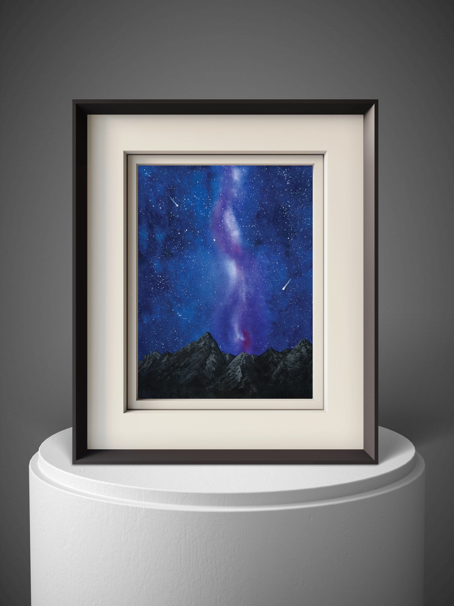 Framed artwork of a starry night sky with mountains on a gray background